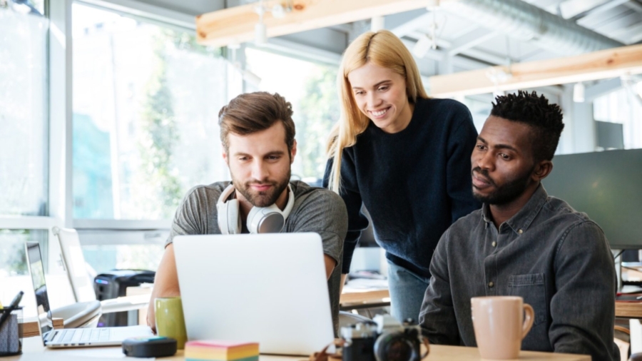 happy-colleagues-sitting-in-office-coworking-PHYA6TG-2000x1125